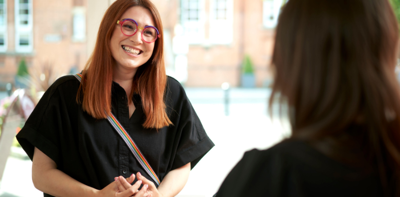 A patient wearing their colourful new glasses at Bainbridge Bespoke Opticians