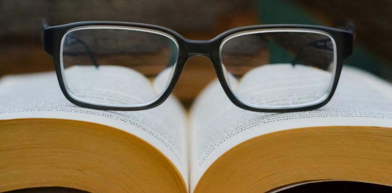 A pair of optical glasses on top of an opened book
