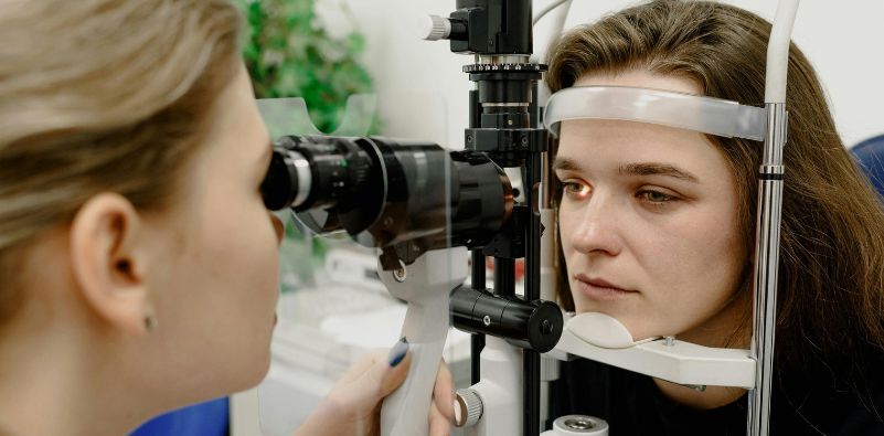 A woman getting her eyes tested with a female optometrist