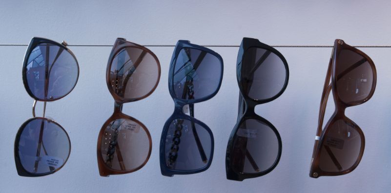 A selection of sunglasses displayed side-by-side on a string